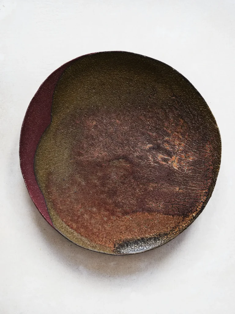 Dunkelbrauner Stoneware-Teller mit dunkelroten und goldfarbenen Glasurakzenten