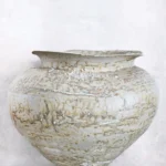 Arrangierte Teller und Becher im Stoneware-Stil von Visual Artist Dietlind Wolf mit sandigen Erd- und Rottönen