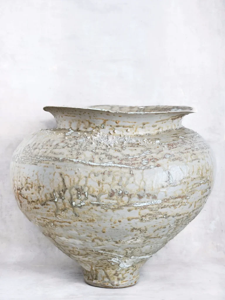 Arrangierte Teller und Becher im Stoneware-Stil von Visual Artist Dietlind Wolf mit sandigen Erd- und Rottönen