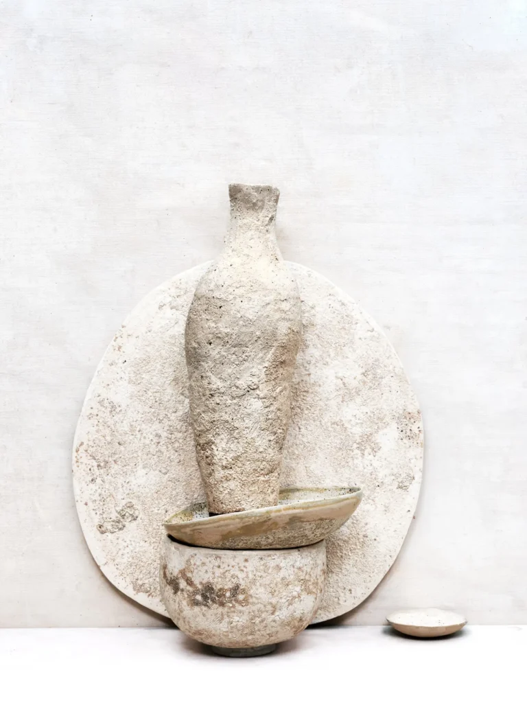 Arrangement von sandfarbenen Vasen, Tellern und Schalen, mir rauer Struktur