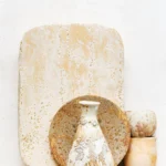 Stoneware-und Porzellan-Arrangement, inszeniert von Dietlind Wolf, mit sandiger Patina und rauer Textur