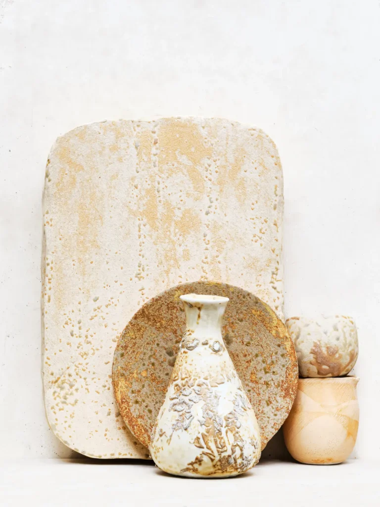 Stoneware-und Porzellan-Arrangement, inszeniert von Dietlind Wolf, mit sandiger Patina und rauer Textur