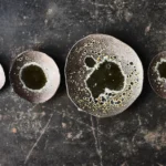 Stoneware-Geschirr in braunem Lava-Ton, arrangiert auf schwaz-gesprenkeltem Hintergrund